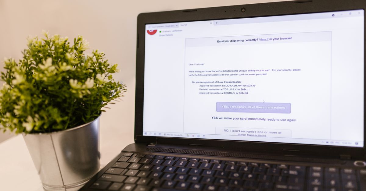 Laptop showing email next to green plant, ideal for tech and productivity concepts.